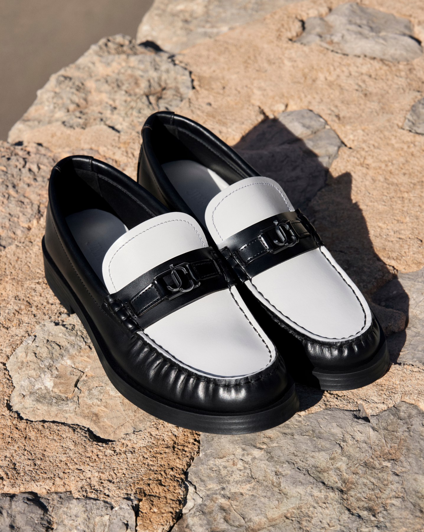 Jimmy Choo black and white loafers with metal emblem