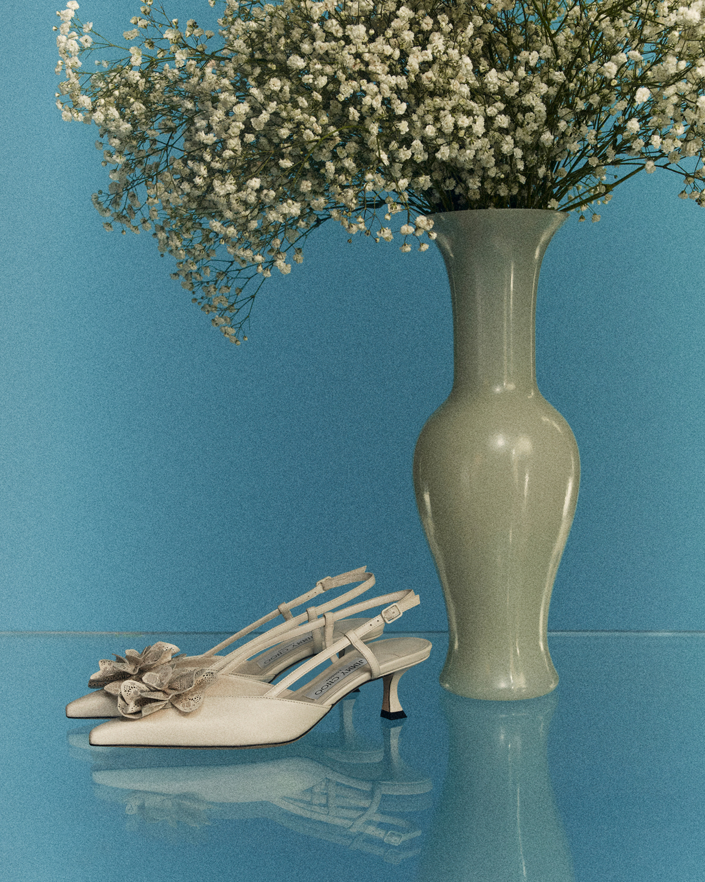 Model wearing black Jimmy Choo sunglasses, an oversized black leather jacket and lace top.