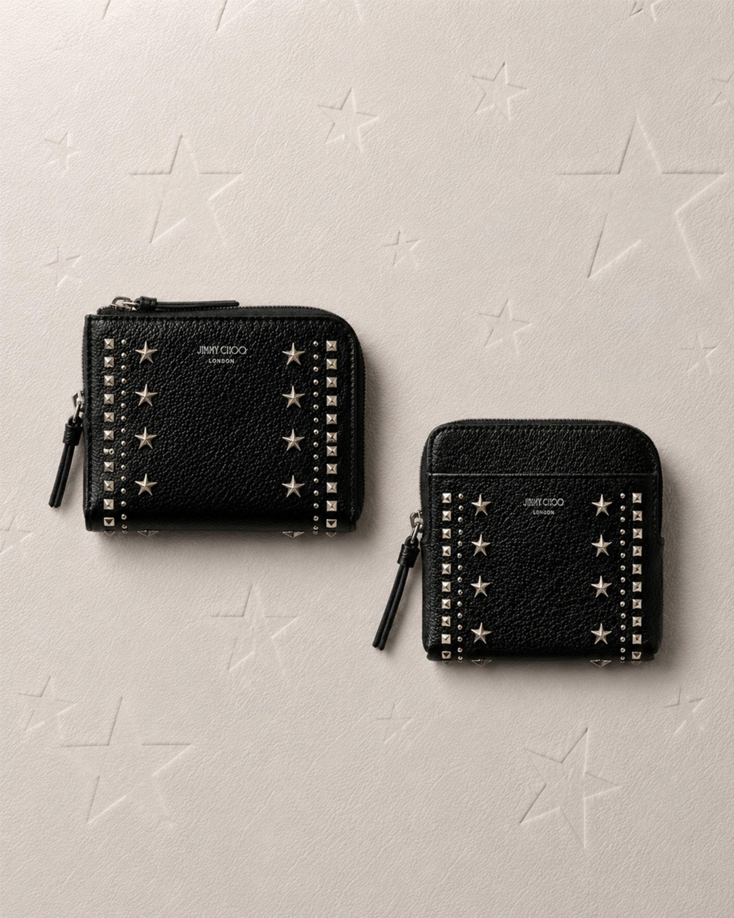 Black leather card holder and wallet with textured finish placed on a leather surface.