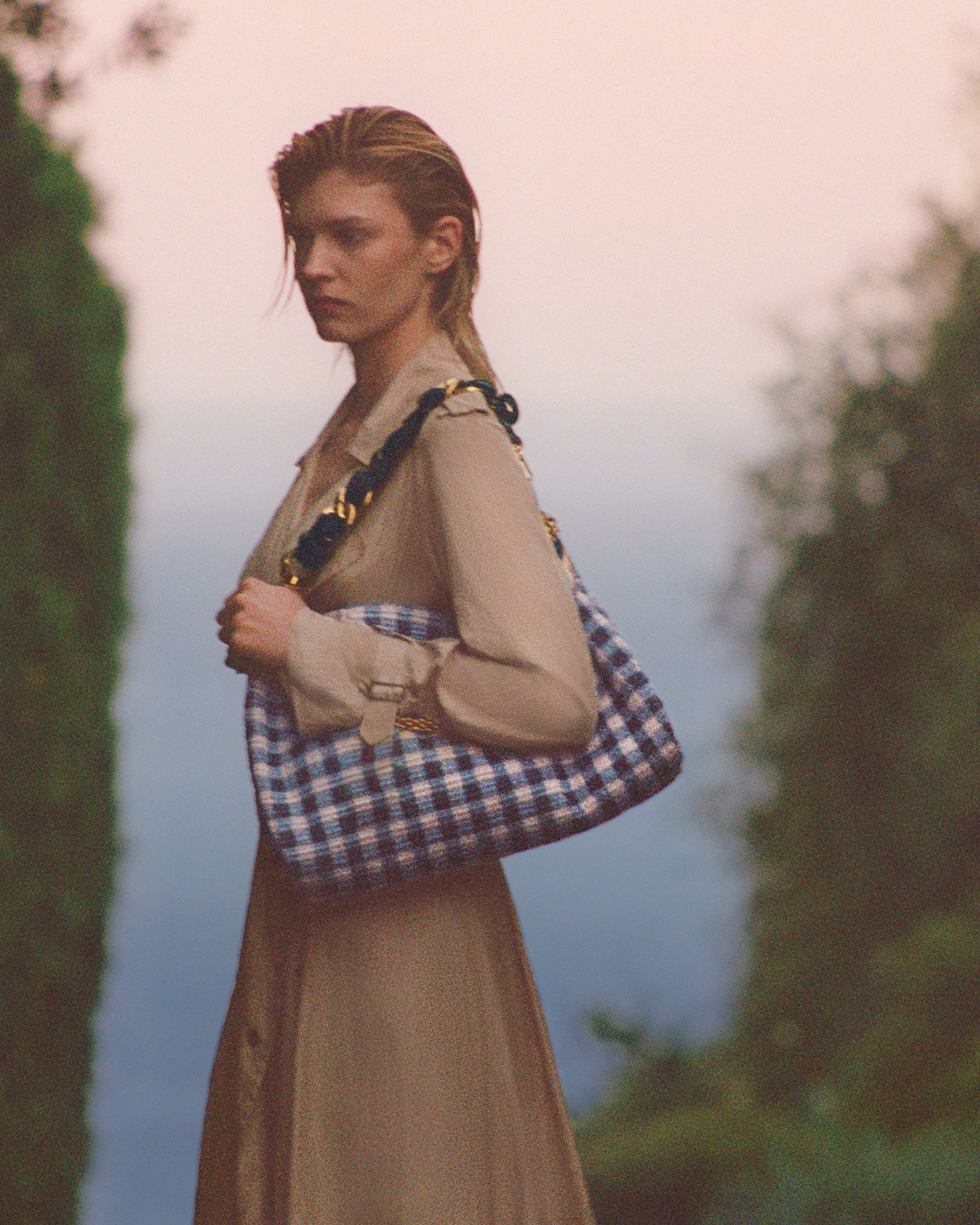 Model wearing black Jimmy Choo sunglasses, an oversized black leather jacket and lace top.