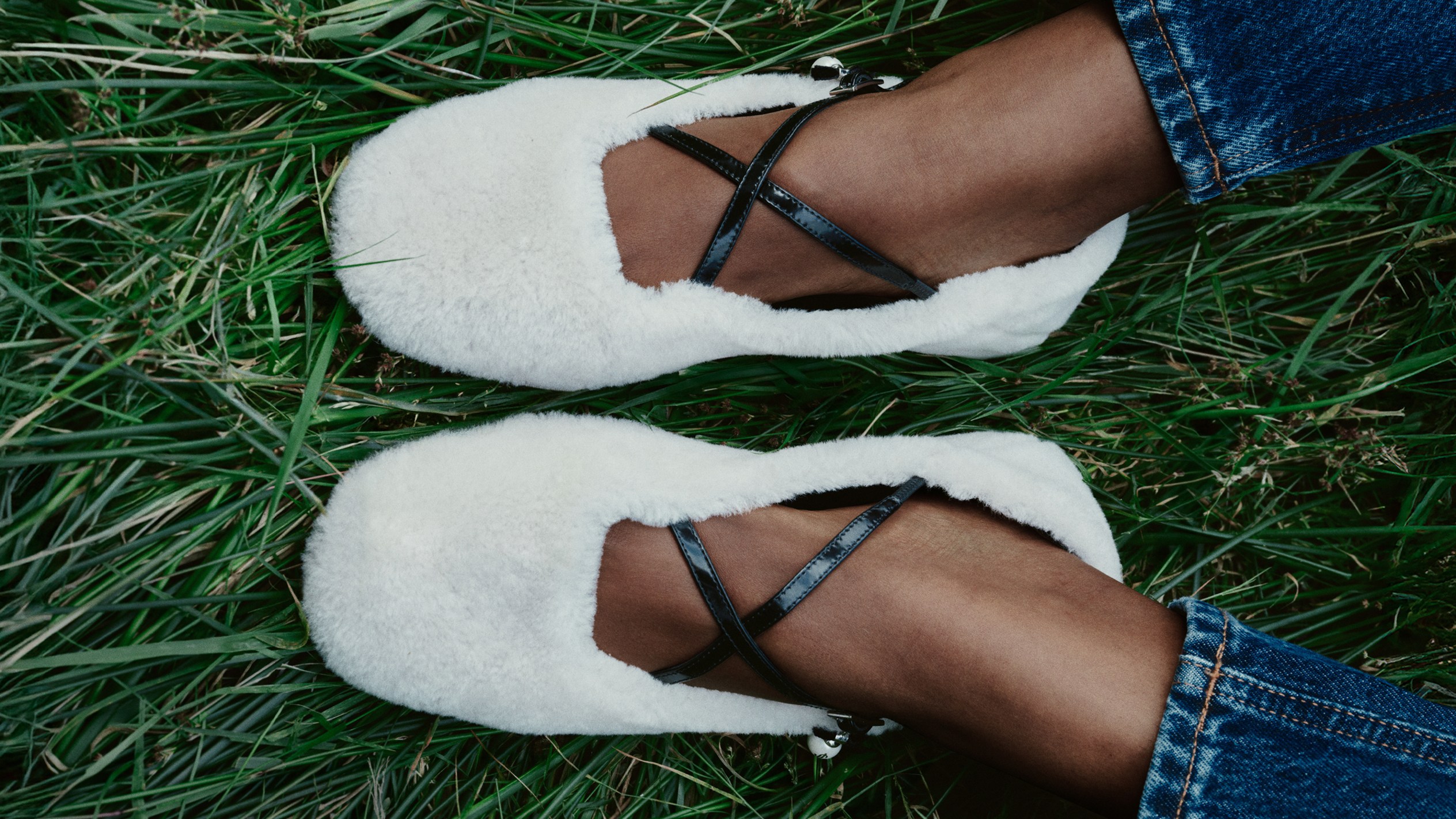 Brown leather ankle boot with chunky sole and cream cable-knit panel, photographed outdoors against a tree trunk in a forest setting.
