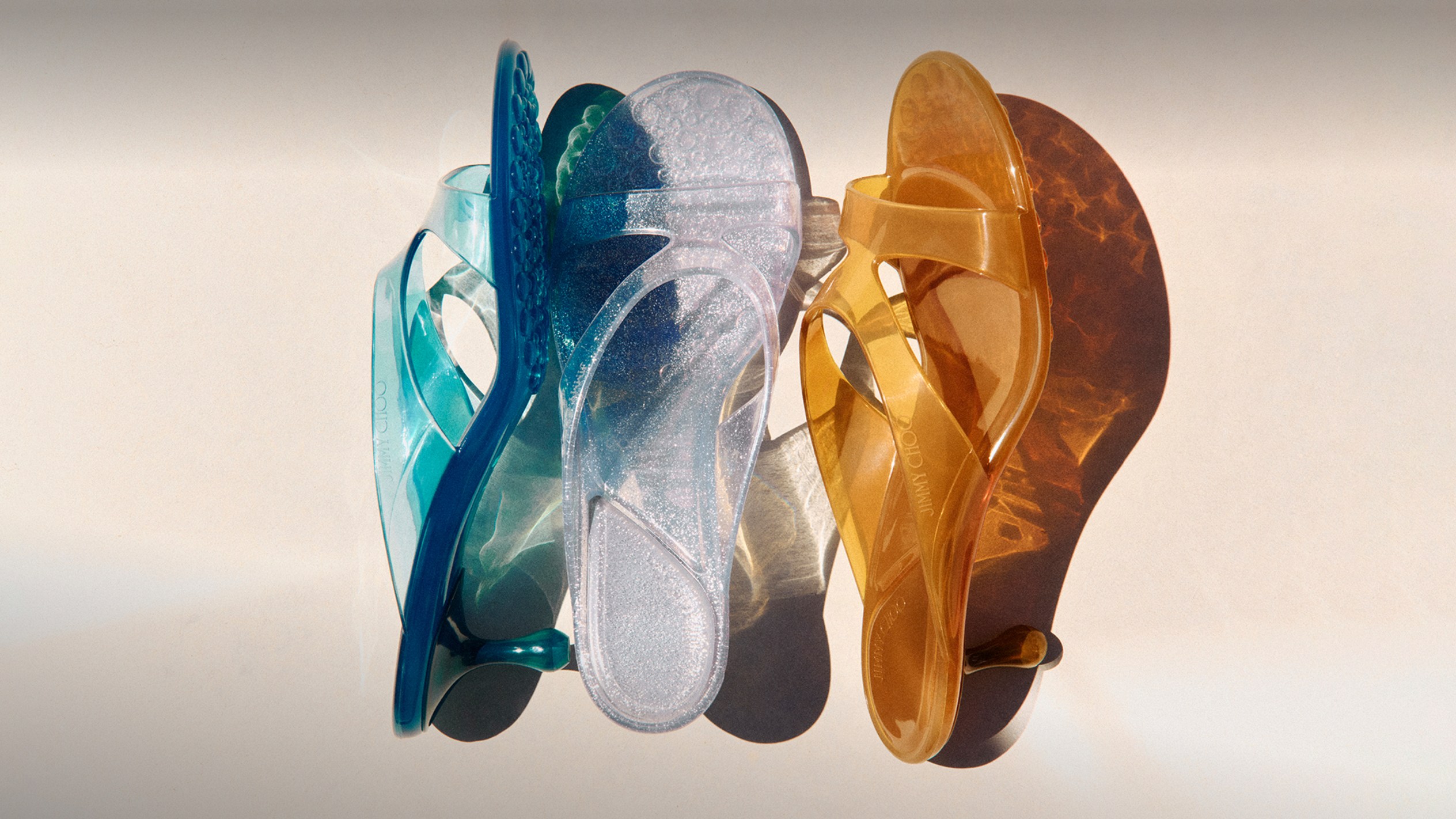 Colourful ballet flats with crystal strap detail arranged side by side on a neutral background.
