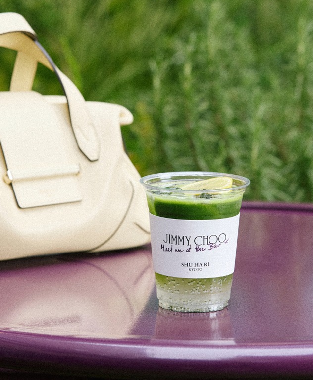 Light yellow handbag beside an iced drink on a caf&eacute; table.