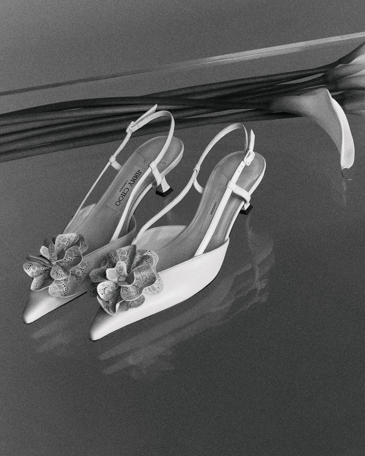 Yellow lace-up trainers with lace overlay, worn with a neutral skirt on brick flooring.