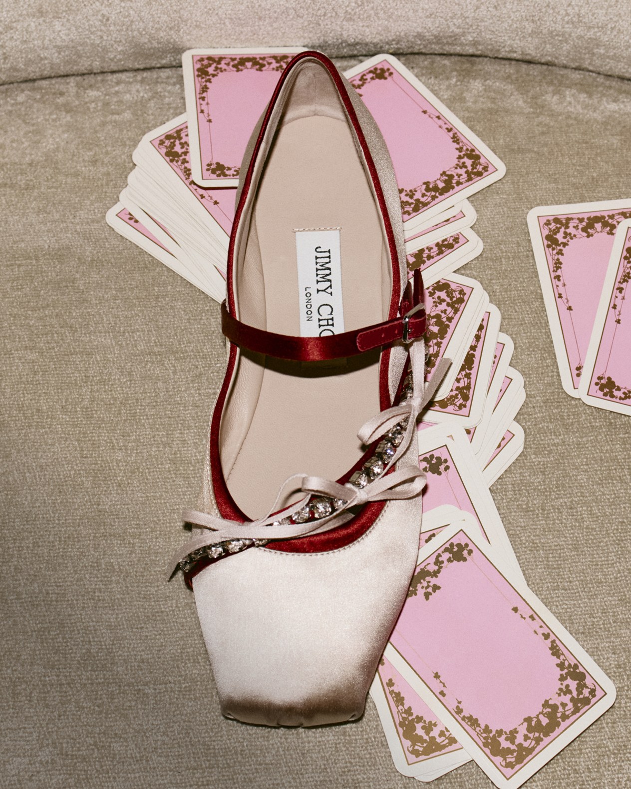 Black leather ankle boot with a mid block heel and sleek silhouette, displayed on a polished wooden chair with chrome details.