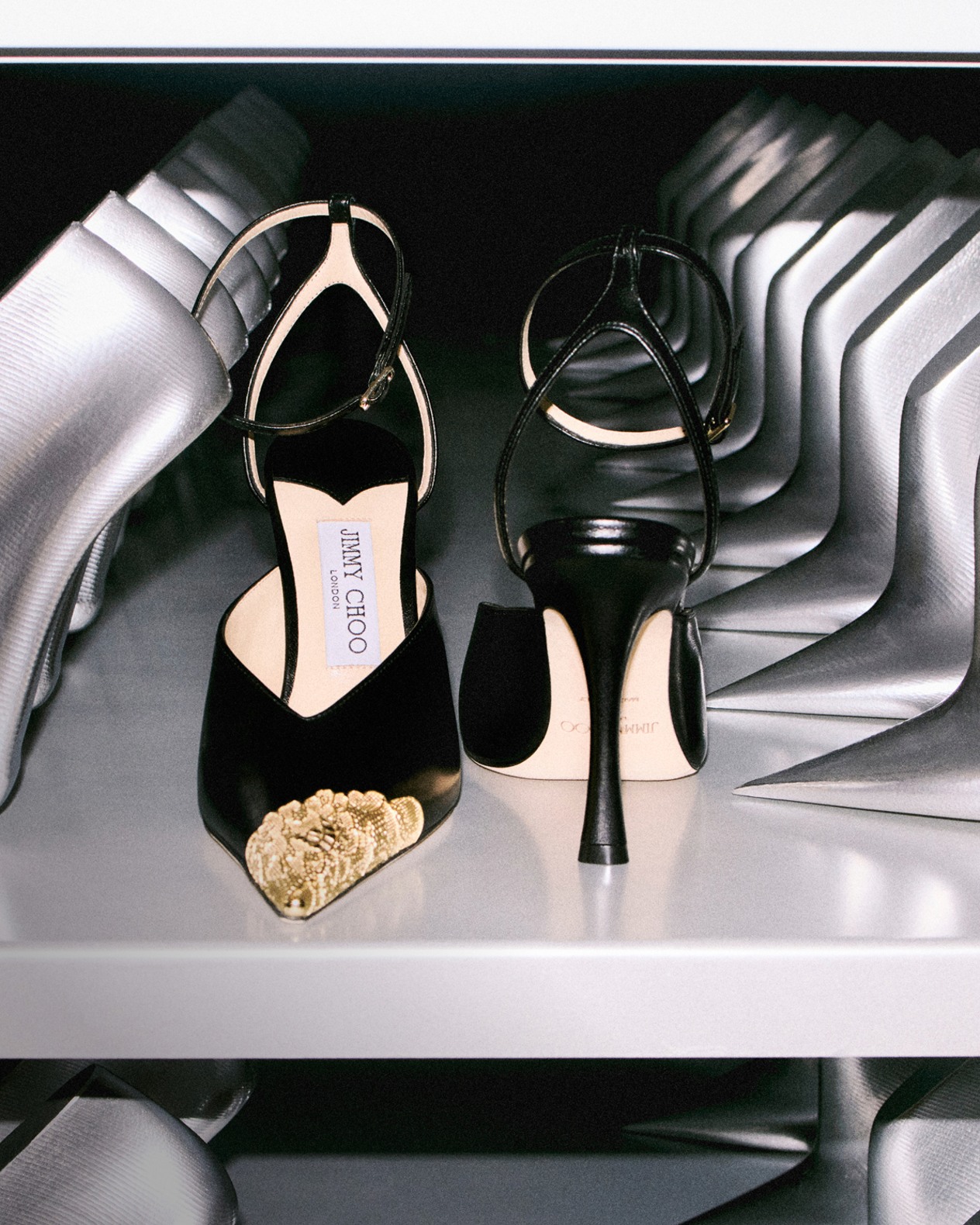 A pair of pointed-toe pumps positioned on a shelf.