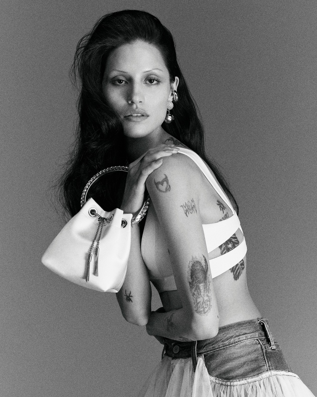 Model holding a white top-handle bridal bag, photographed in black and white.