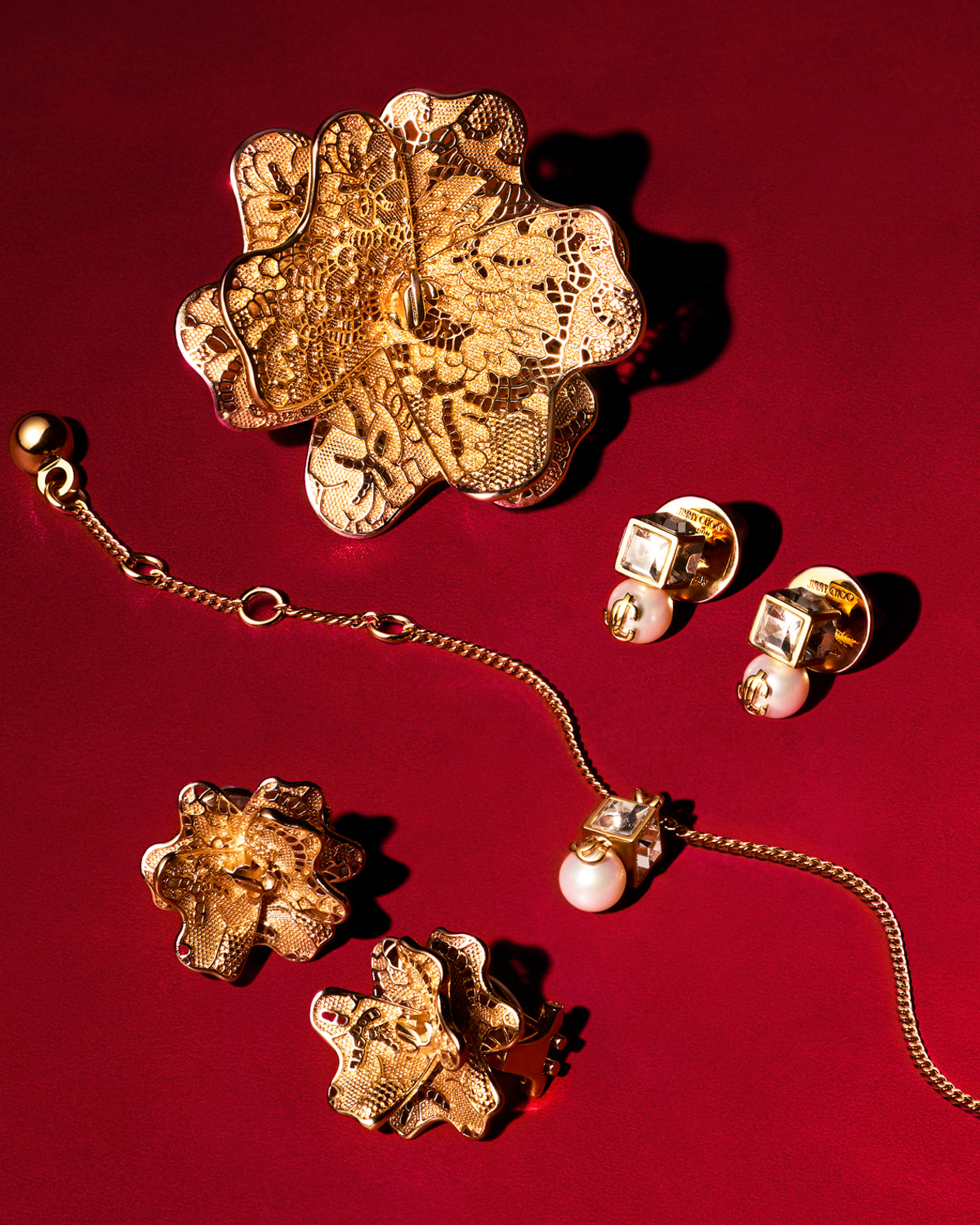 Gold floral jewellery pieces displayed on a fine white plate.