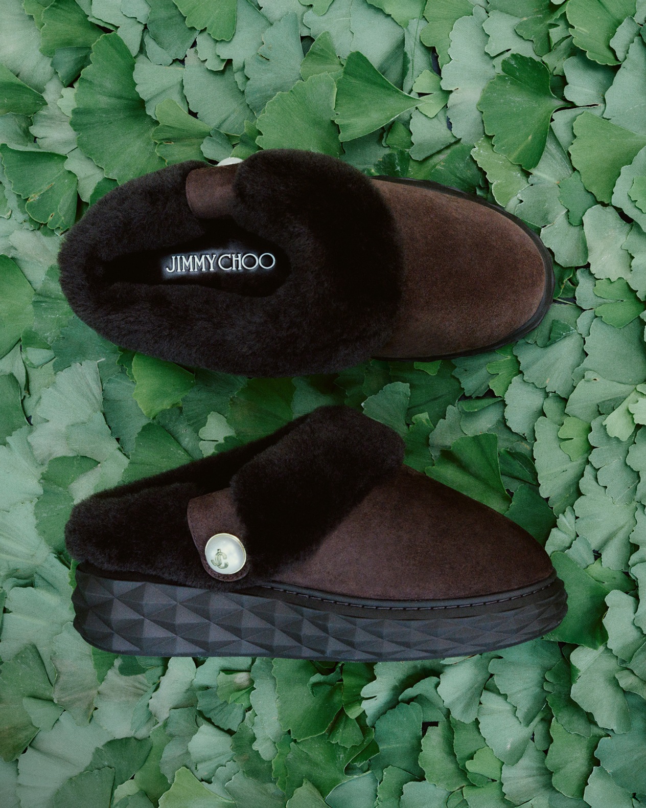 Brown leather ankle boots with chunky sole and cream cable-knit panel, photographed outdoors against a moss-covered tree trunks in a forest setting.