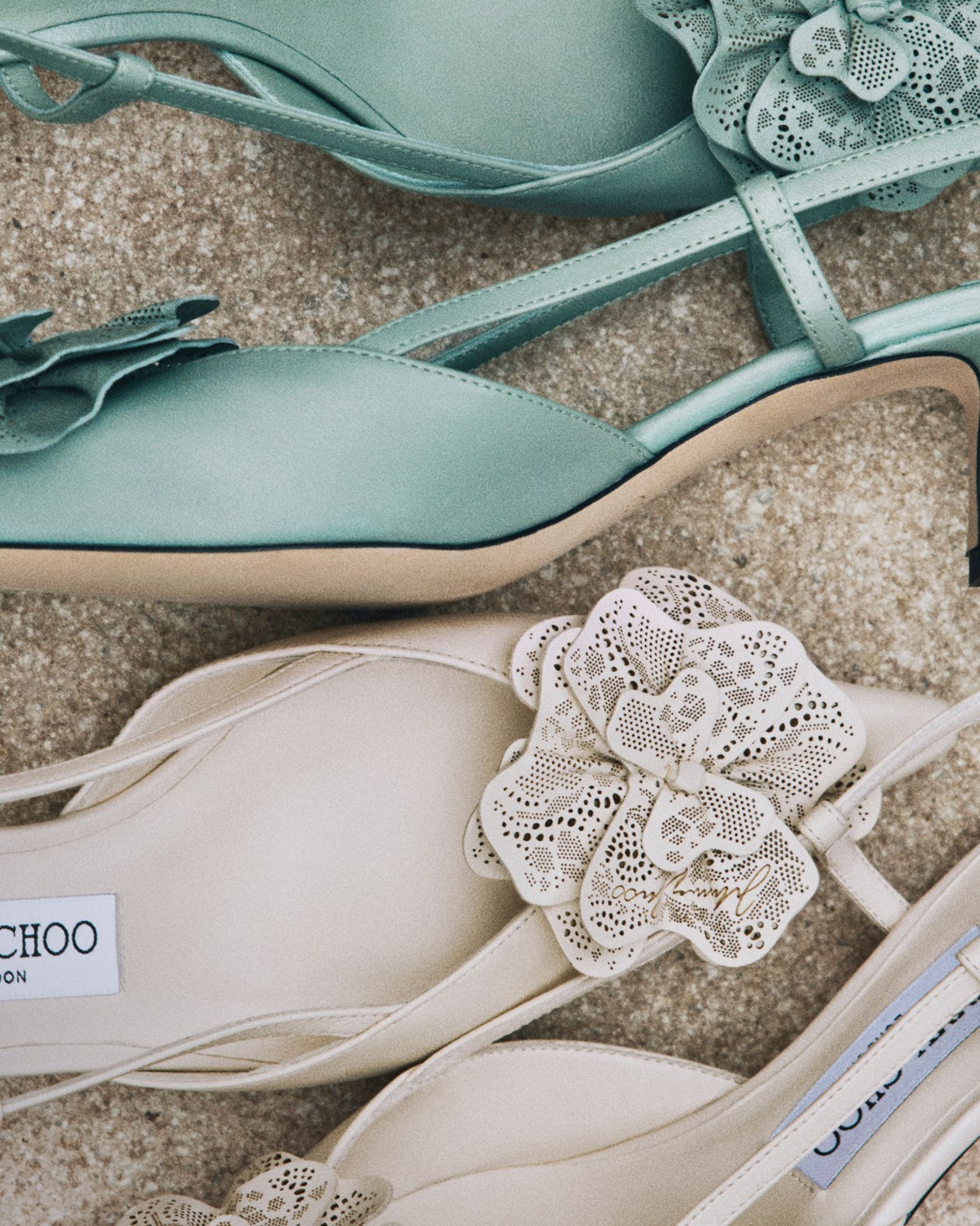 Yellow lace-up trainers with lace overlay, worn with a neutral skirt on brick flooring.