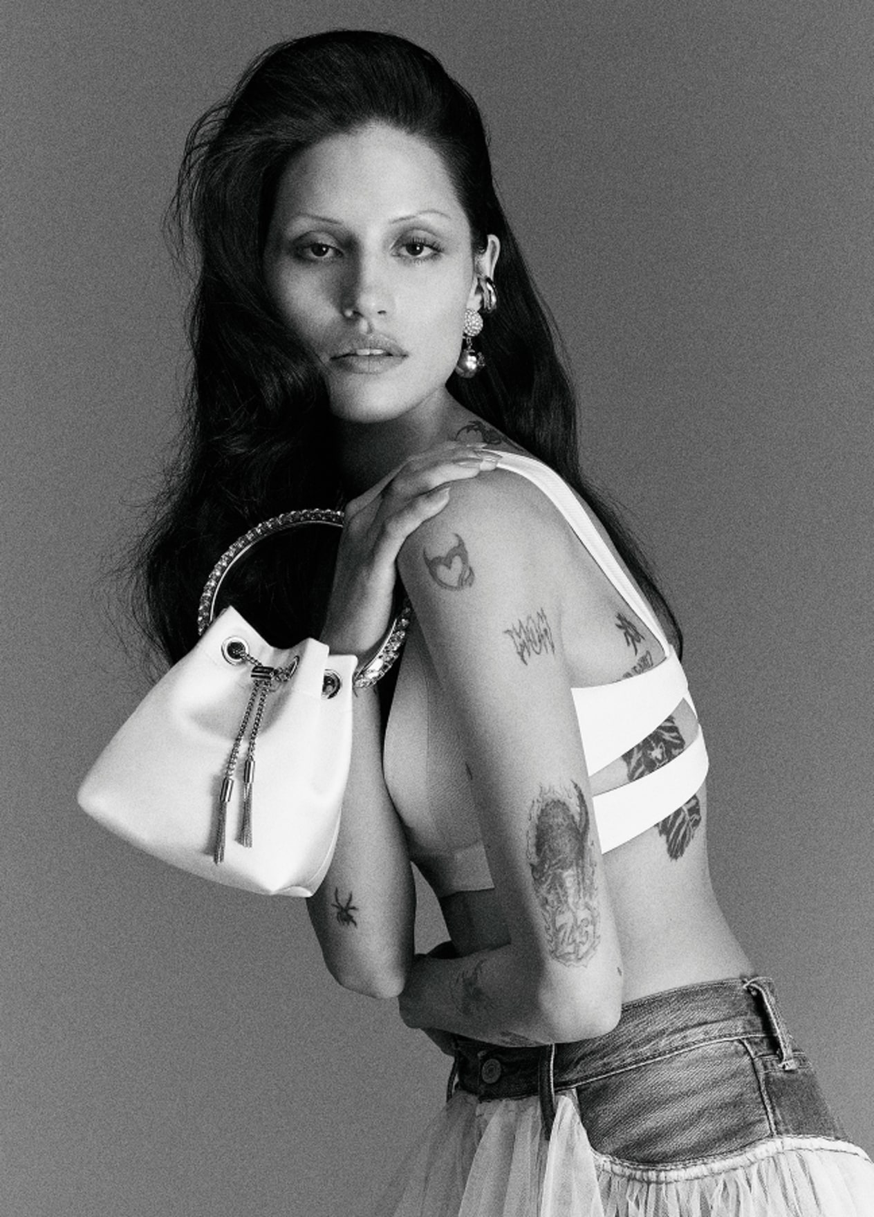 Model holding a white top-handle bridal bag, photographed in black and white.