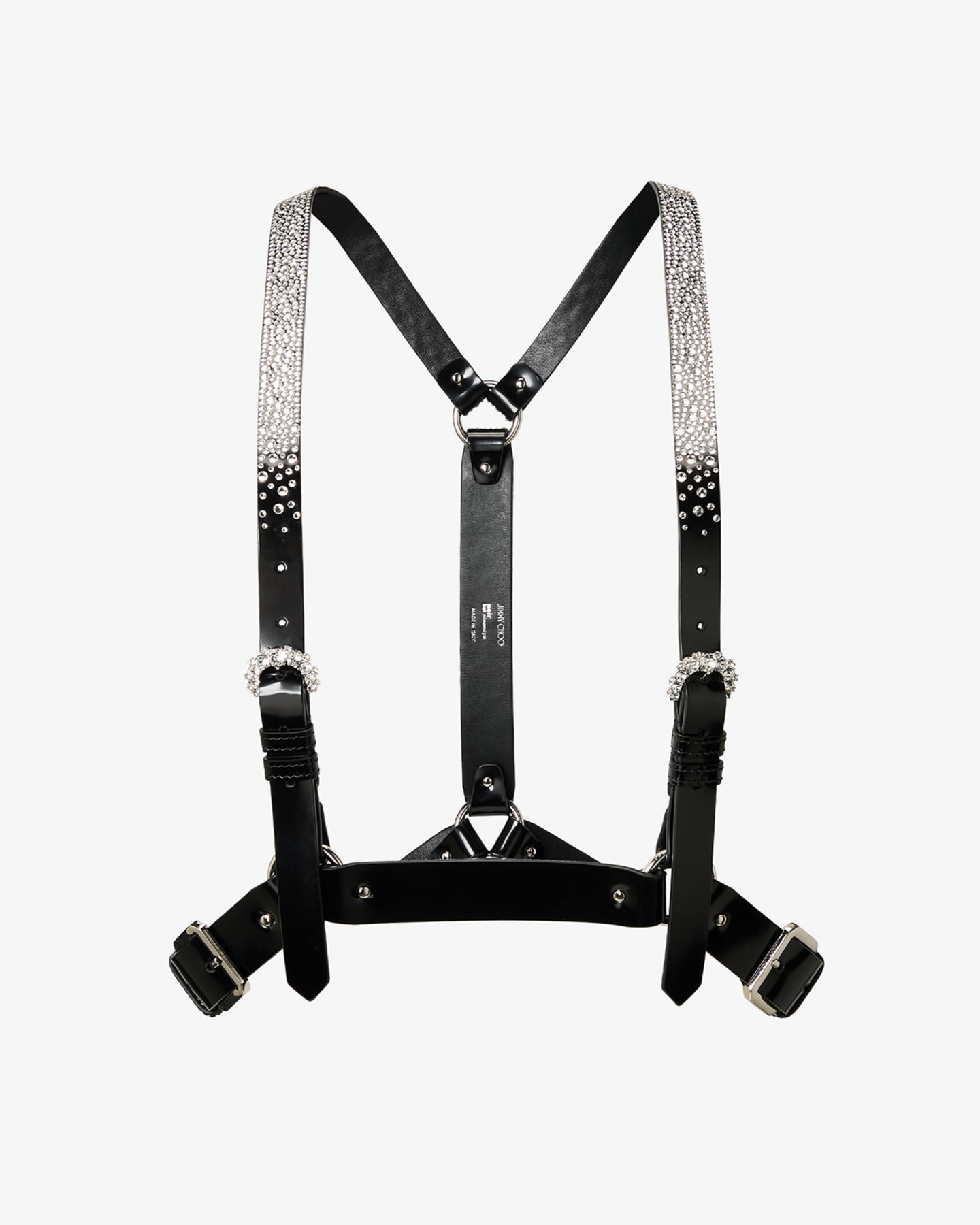 Runway look featuring black leather studded lace-up shoes worn with patterned leggings, a crystal-embellished harness and layered tailoring.