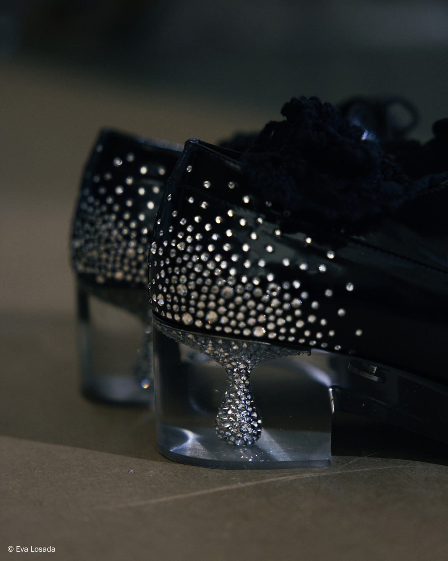 Black leather lace-up shoes with crystal-embellished and plexi heel, worn with sheer socks.