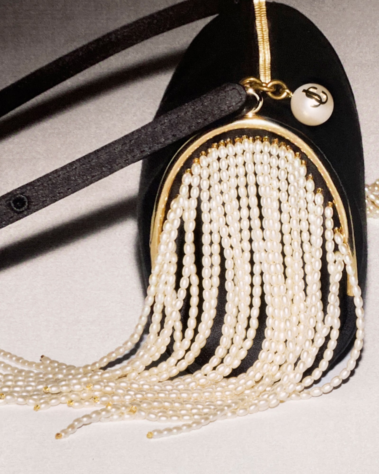 Close up of black bag with pearl fringe detailing.