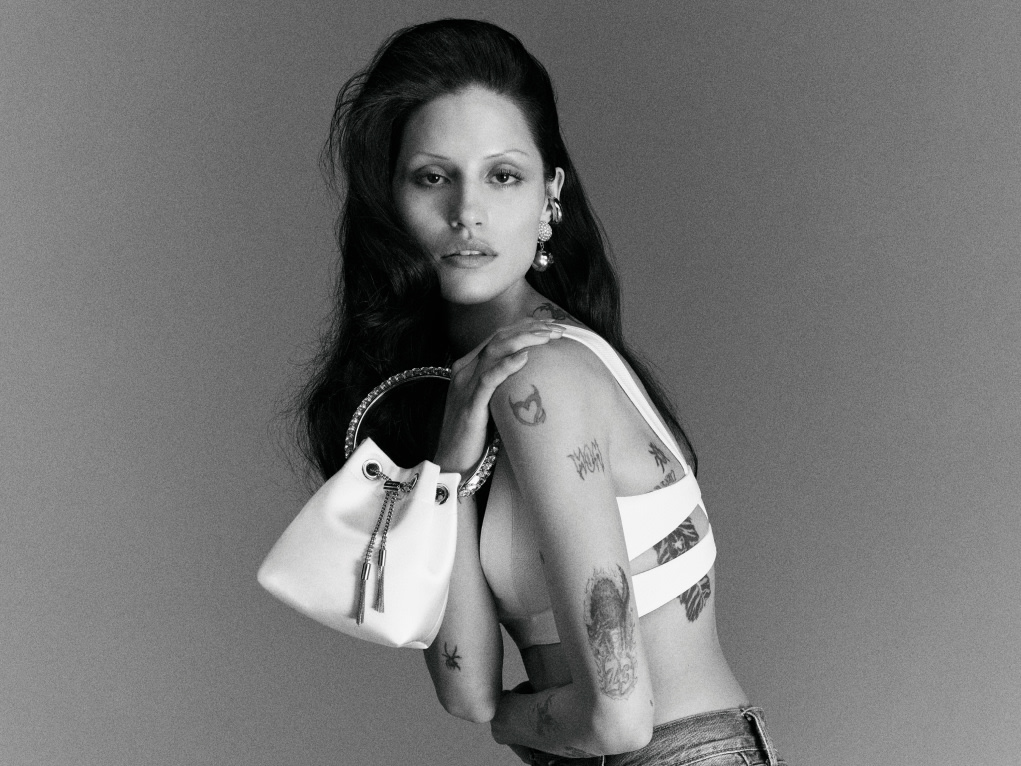 Model holding a white top-handle bridal bag, photographed in black and white.